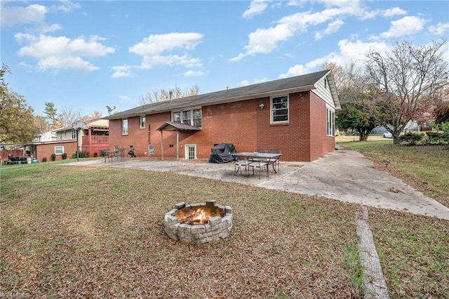 back of house featuring a fire pit, a patio area, and a yard