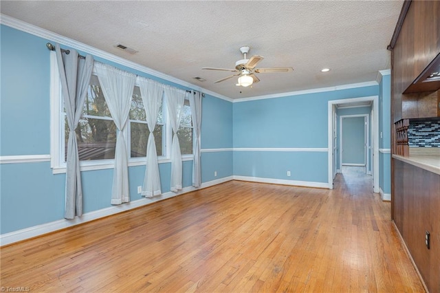 interior space with ceiling fan, light hardwood / wood-style floors, ornamental molding, and a textured ceiling