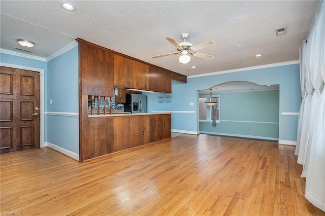 kitchen with kitchen peninsula, stainless steel fridge, a textured ceiling, ceiling fan, and light hardwood / wood-style floors