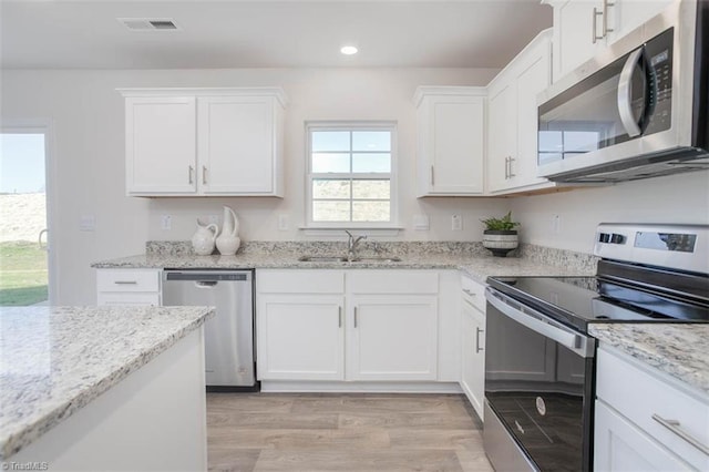 248 Warbler Way, Lexington, NC 27295 - kitchen featuring appliances with stainless steel finishes, a sink, light wood-style flooring, white cabinetry, and recessed lighting
