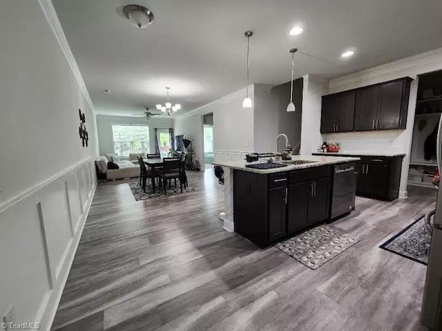 kitchen featuring a kitchen island with sink, hardwood / wood-style floors, crown molding, and stainless steel dishwasher