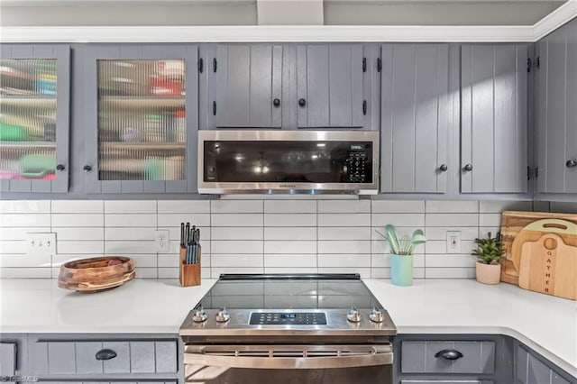 kitchen featuring stainless steel appliances, decorative backsplash, and gray cabinetry