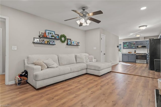 living room with ceiling fan and light wood-type flooring