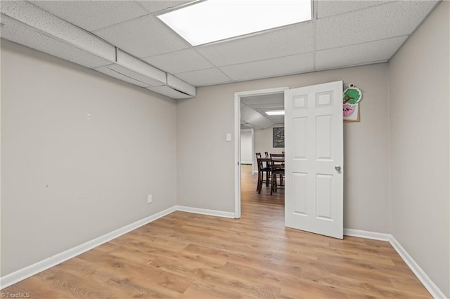 spare room with a drop ceiling and hardwood / wood-style floors