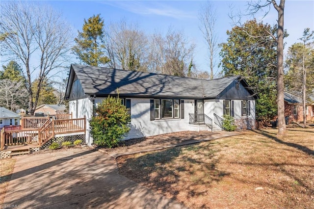 view of front of house with a wooden deck and a front yard