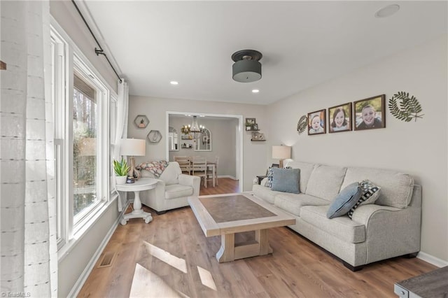 living room with an inviting chandelier and hardwood / wood-style floors