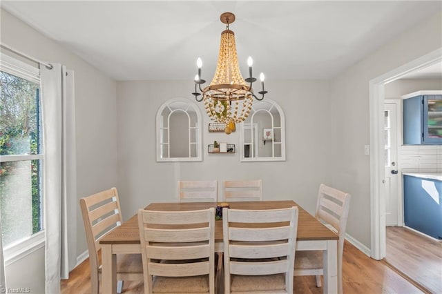 dining area with a chandelier, light hardwood / wood-style flooring, and a wealth of natural light