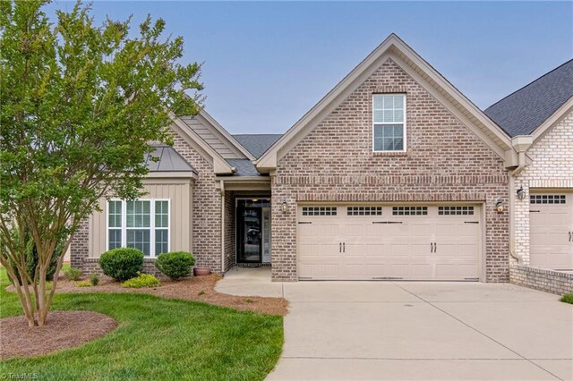 241 Collingswood Dr, Winston-Salem, NC 27127 - view of front of home featuring brick siding, concrete driveway, a garage, a front lawn, and board and batten siding