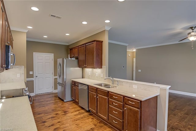 241 Collingswood Dr, Winston-Salem, NC 27127 - kitchen with appliances with stainless steel finishes, a sink, ceiling fan, wood finished floors, and a peninsula