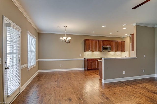241 Collingswood Dr, Winston-Salem, NC 27127 - kitchen with stainless steel microwave, a chandelier, dark wood-type flooring, brown cabinetry, and a ceiling fan