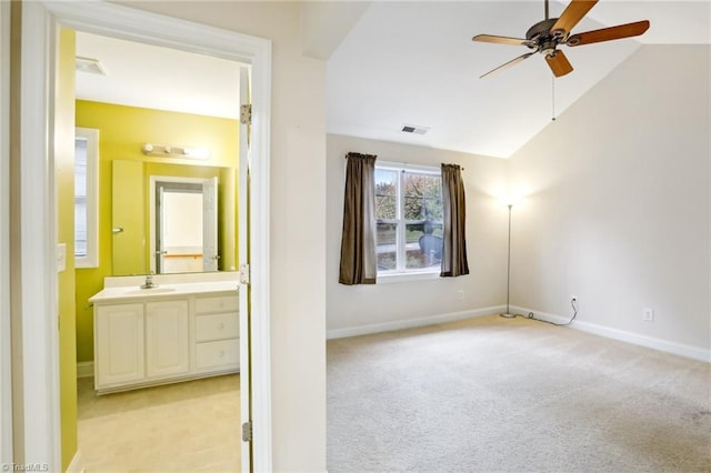 spare room with ceiling fan, light carpet, and vaulted ceiling