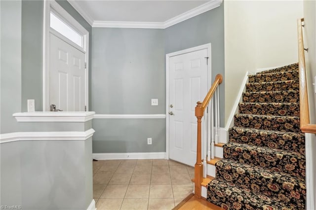 foyer with light tile patterned floors and crown molding