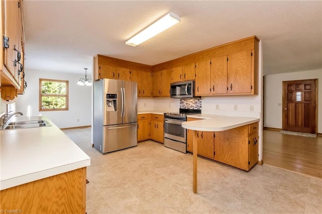 kitchen with tasteful backsplash, stainless steel appliances, sink, pendant lighting, and a chandelier