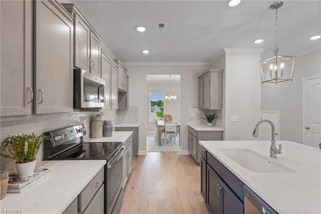 1416 Prospect Hill St, Kernersville, NC 27284 - kitchen featuring appliances with stainless steel finishes, a chandelier, a sink, ornamental molding, and recessed lighting
