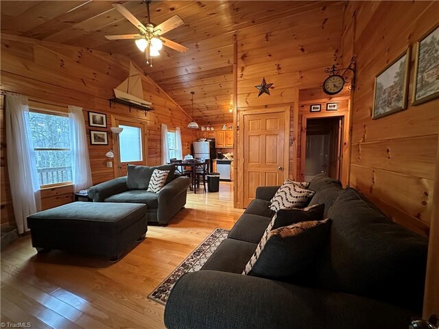 living room with ceiling fan, wooden ceiling, wood walls, light hardwood / wood-style floors, and lofted ceiling