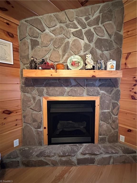 room details featuring wood walls and a fireplace