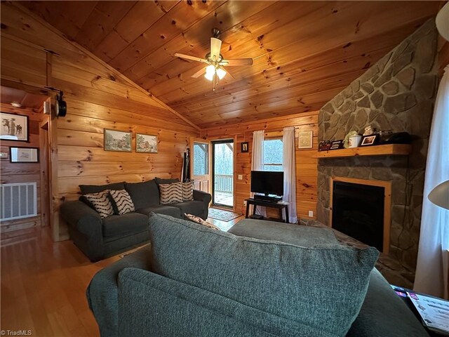 living room featuring lofted ceiling, ceiling fan, a fireplace, wood-type flooring, and wood ceiling