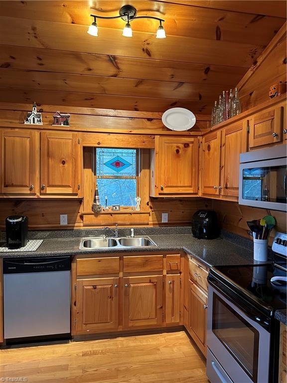 kitchen featuring wooden ceiling, sink, appliances with stainless steel finishes, and light hardwood / wood-style flooring