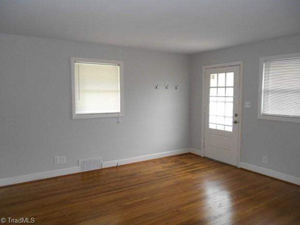 doorway to outside featuring visible vents, baseboards, and wood finished floors