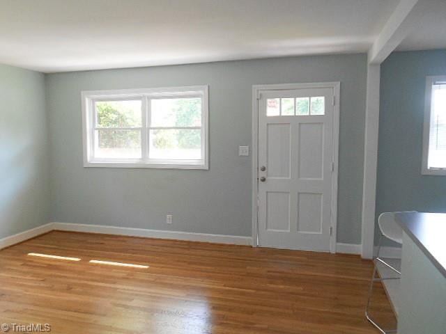 foyer featuring light wood-style floors and baseboards