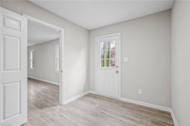 entryway with a textured ceiling and light hardwood / wood-style floors