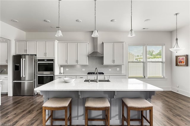 kitchen with appliances with stainless steel finishes, a sink, dark wood-style floors, and backsplash