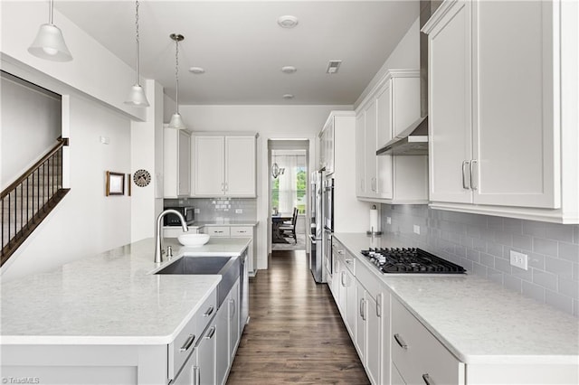 kitchen with gas cooktop, a sink, dark wood finished floors, decorative backsplash, and hanging light fixtures
