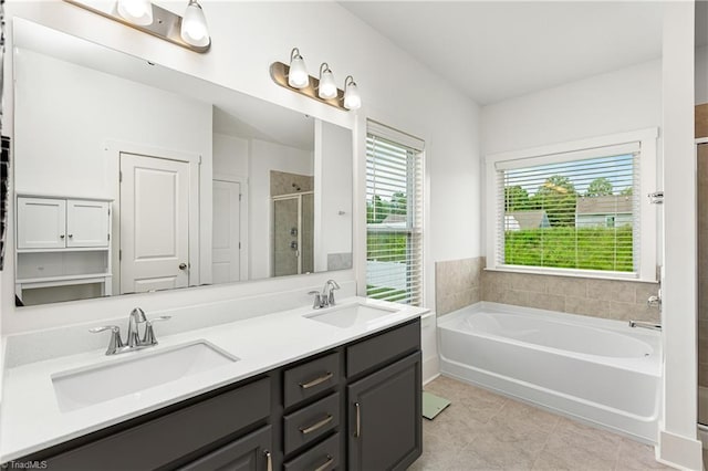 bathroom with a stall shower, a garden tub, double vanity, and tile patterned floors