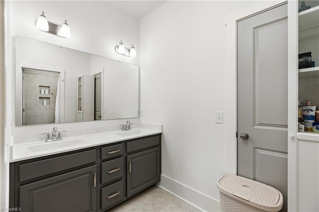 full bathroom featuring baseboards, double vanity, and tile patterned flooring