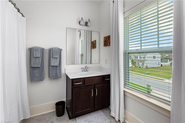 bathroom with baseboards, tile patterned flooring, and vanity
