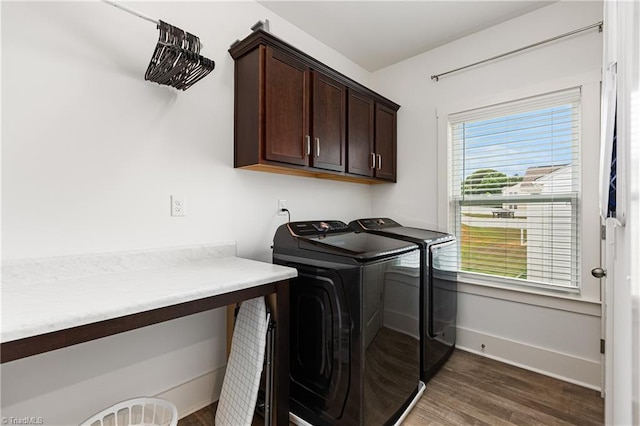 laundry room featuring separate washer and dryer, cabinet space, dark wood-type flooring, and baseboards