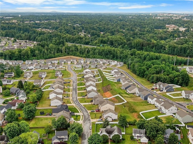 aerial perspective of suburban area featuring a heavily wooded area