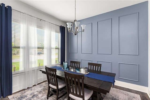 dining space featuring a chandelier, wood finished floors, and baseboards