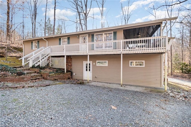 back of house with a deck and ceiling fan