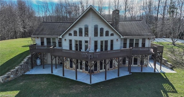 rear view of property with a patio area, a chimney, a deck, and a yard