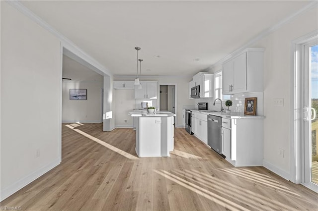 kitchen with white cabinets, stainless steel appliances, light countertops, and light wood-style floors