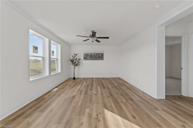 spare room with light wood-style flooring, baseboards, and ornamental molding