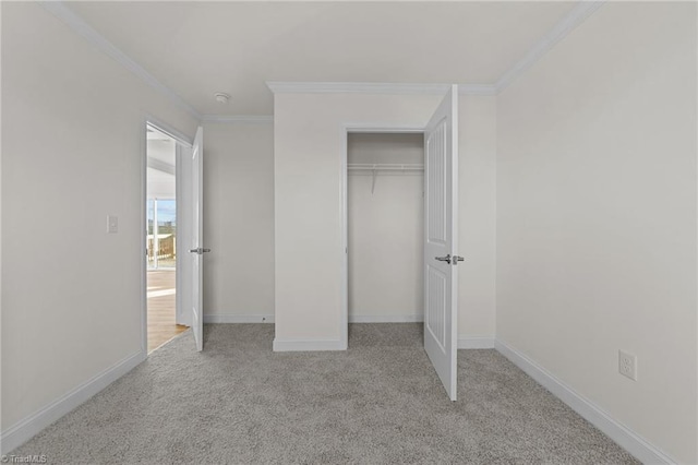 unfurnished bedroom featuring a closet, carpet floors, baseboards, and ornamental molding