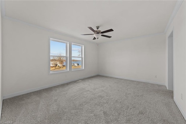 carpeted spare room featuring baseboards, a ceiling fan, and ornamental molding