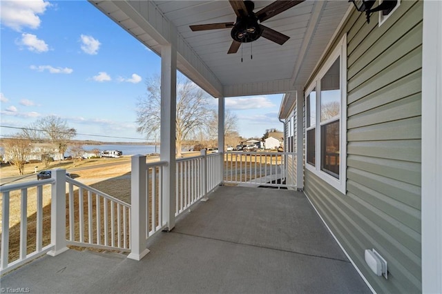 view of patio / terrace featuring a water view, a porch, and a ceiling fan