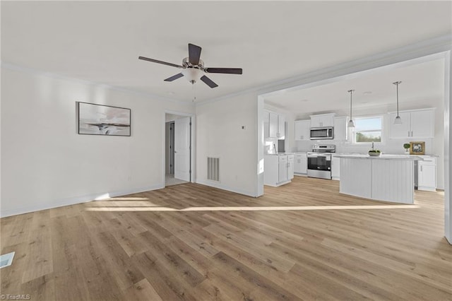 unfurnished living room featuring crown molding, light wood-style flooring, baseboards, and visible vents