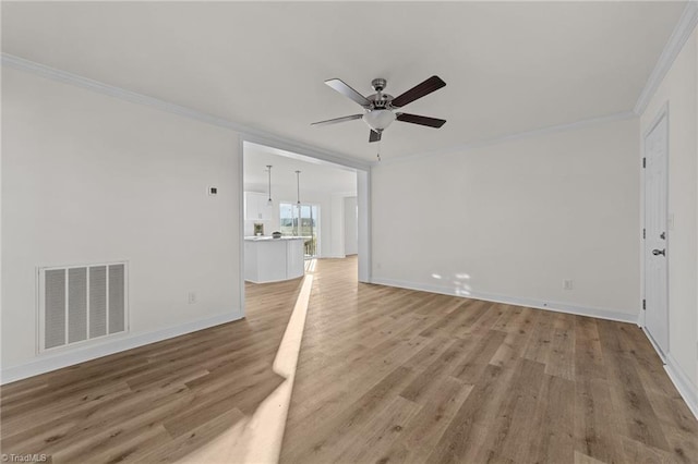 unfurnished room featuring visible vents, crown molding, baseboards, ceiling fan, and light wood-type flooring