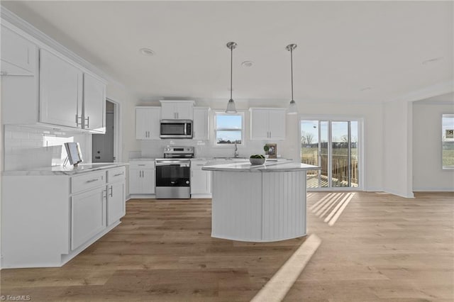 kitchen featuring light countertops, white cabinets, tasteful backsplash, and stainless steel appliances