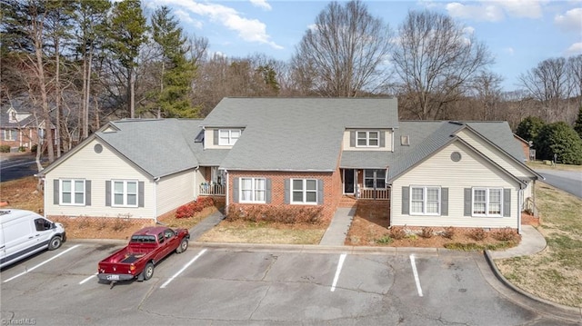 view of front of house featuring uncovered parking and brick siding