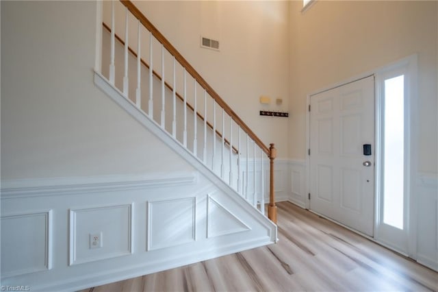 6015 Accord Ct, Pfafftown, NC 27040 - foyer featuring a decorative wall, stairway, wood finished floors, a wainscoted wall, and a towering ceiling