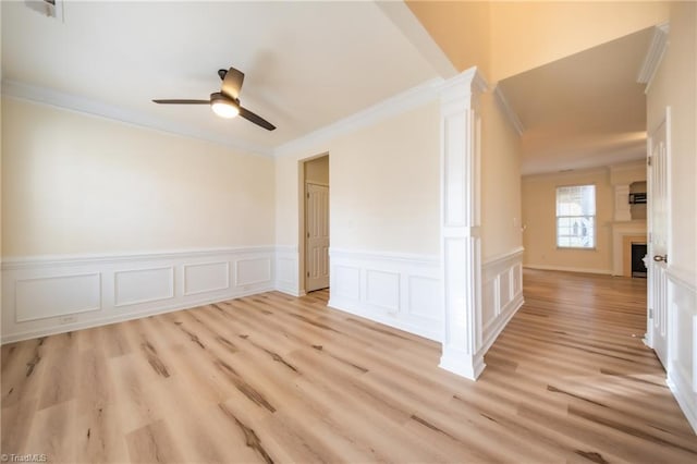 6015 Accord Ct, Pfafftown, NC 27040 - unfurnished room with crown molding, a ceiling fan, a wainscoted wall, light wood-style flooring, and a fireplace