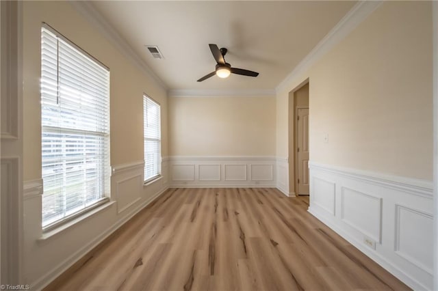 6015 Accord Ct, Pfafftown, NC 27040 - spare room featuring a ceiling fan, crown molding, a wainscoted wall, light wood finished floors, and a decorative wall