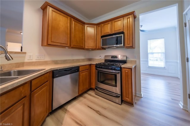 6015 Accord Ct, Pfafftown, NC 27040 - kitchen featuring appliances with stainless steel finishes, crown molding, light wood-type flooring, and brown cabinets