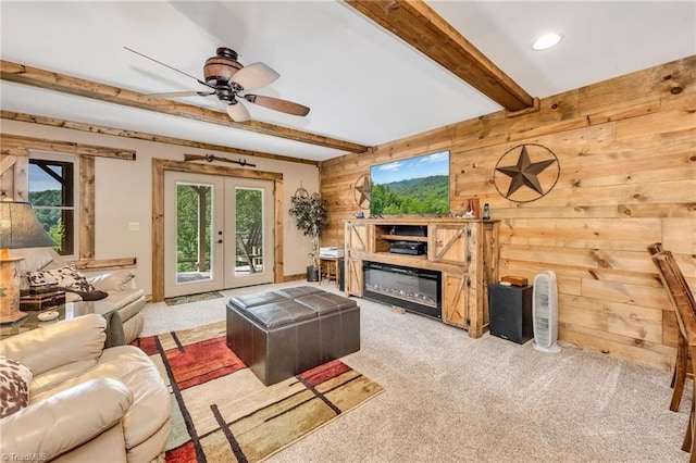 883 Wagon Ridge Ln, Ferguson, NC 28624 - carpeted living area featuring beam ceiling, french doors, wooden walls, ceiling fan, and a glass covered fireplace