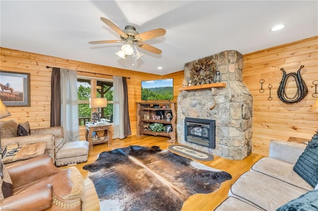 883 Wagon Ridge Ln, Ferguson, NC 28624 - living room with wooden walls, wood finished floors, a fireplace, ceiling fan, and recessed lighting
